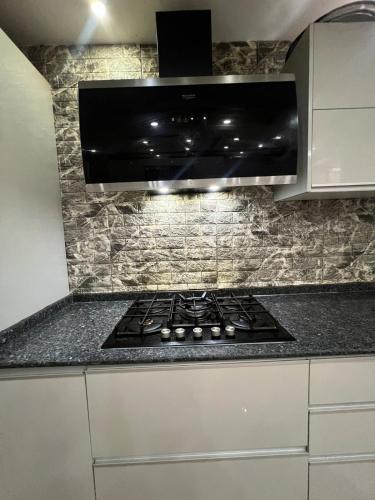 a stove top in a kitchen with a microwave at Villa 3 niveau avec jacuzzi, terrasse et cour in Birkhadem