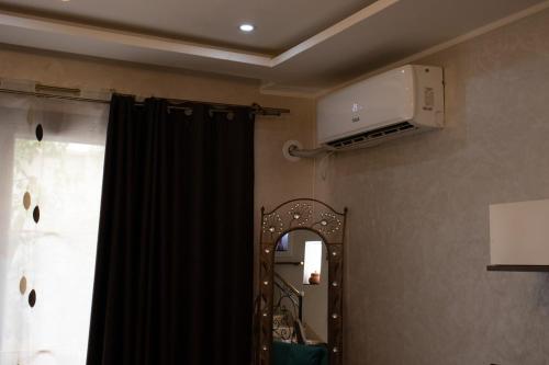 a room with a mirror and a tv on the wall at Villa 3 niveau avec jacuzzi, terrasse et cour in Birkhadem