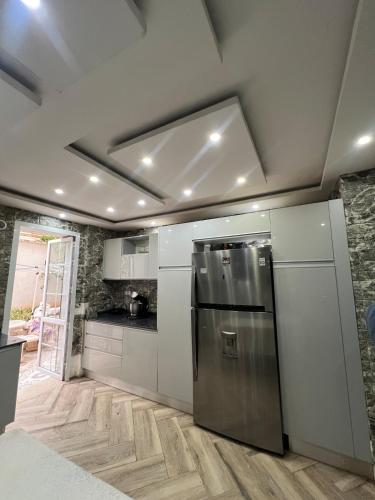 a kitchen with a stainless steel refrigerator in a room at Villa 3 niveau avec jacuzzi, terrasse et cour in Birkhadem