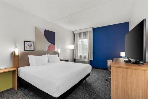 a hotel room with a large bed and a flat screen tv at Spark by Hilton Lexington Hamburg in Lexington