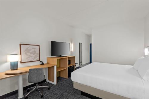 a hotel room with a bed and a desk with a computer at Spark by Hilton Lexington Hamburg in Lexington