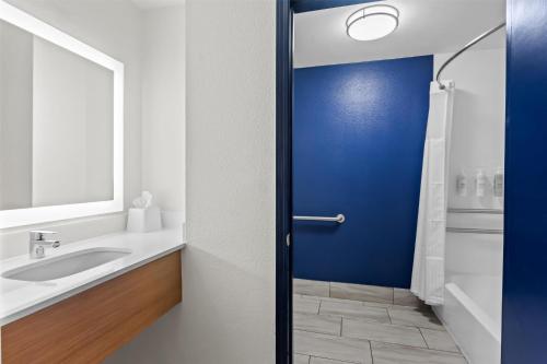 a bathroom with a blue door and a sink at Spark by Hilton Lexington Hamburg in Lexington