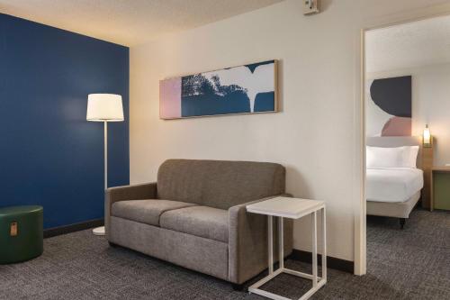 a room with a couch and a bed and a mirror at Spark By Hilton Germantown Washington Dc North in Germantown