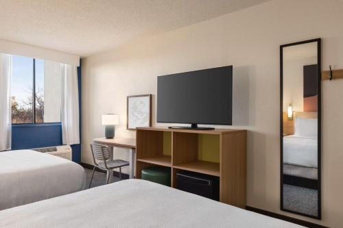 a hotel room with two beds and a flat screen tv at Spark By Hilton Germantown Washington Dc North in Germantown