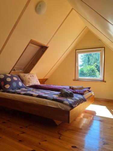 a large bed in a room with a window at Domki Pod Lasem in Macharce