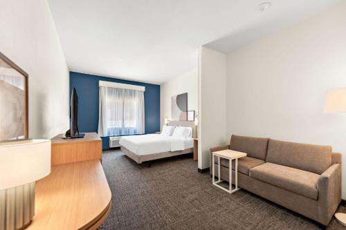 MansfieldにあるSpark By Hilton Mansfieldのソファとベッドのあるホテルの部屋