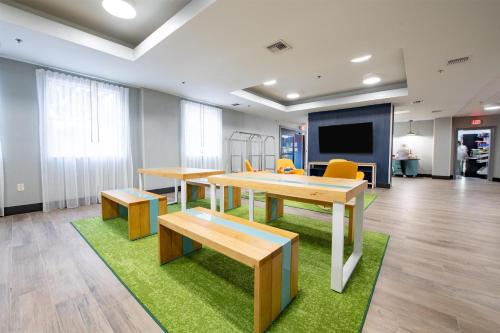 une salle de classe avec des tables, des chaises et un écran dans l'établissement Spark By Hilton Lafayette South, à Lafayette