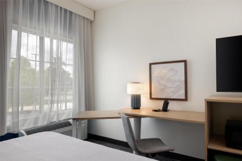 a hotel room with a desk and a window at Spark by Hilton Hammond in Hammond