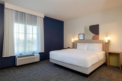 a hotel room with a large bed and a window at Spark by Hilton Hammond in Hammond