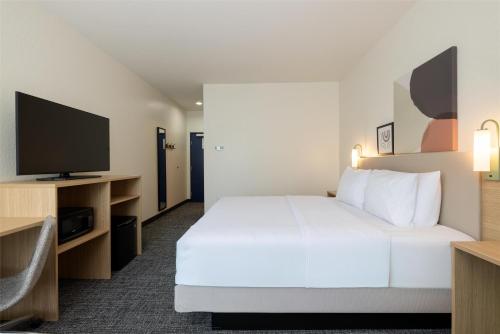 a hotel room with a bed and a flat screen tv at Spark by Hilton Hammond in Hammond