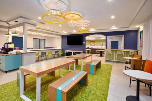 a classroom with tables and chairs and a cafeteria at Spark by Hilton Walker Grand Rapids North in Grand Rapids