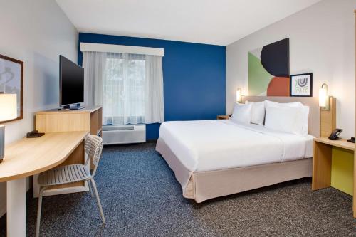 a hotel room with a large bed and a desk at Spark by Hilton Walker Grand Rapids North in Grand Rapids
