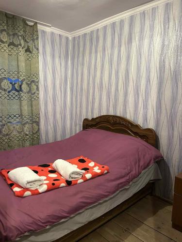 a bed with two pillows on it in a bedroom at Guesthouse Lika in Ushguli