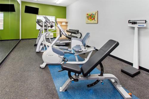 a gym with several treadmills and elliptical machines at Spark by Hilton Rochester South in Rochester