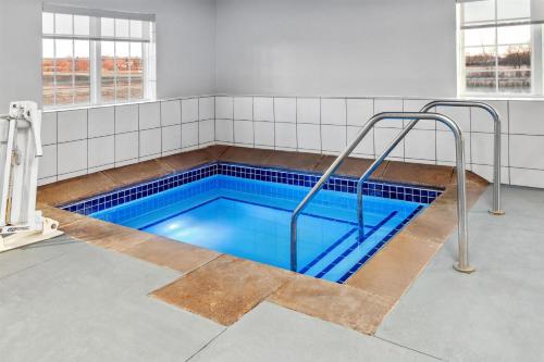 a swimming pool with blue water in a room at Spark by Hilton Rochester South in Rochester