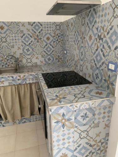 a kitchen with blue and white tiles on the wall at A 100 m dalla spiaggia in Torre Mozza