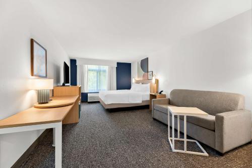 a hotel room with a couch and a bed at Spark By Hilton Tupelo in Tupelo