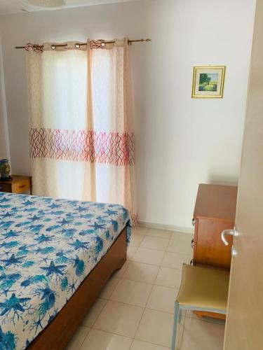 a bedroom with a bed and a curtain in a room at A 100 m dalla spiaggia in Torre Mozza