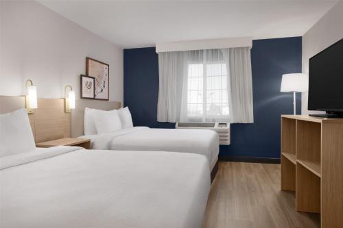 a hotel room with two beds and a television at Spark By Hilton Albuquerque North I-25 in Albuquerque