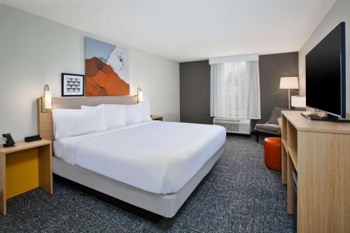 a hotel room with a large bed and a flat screen tv at Spark By Hilton Jackson Ridgeland in Jackson