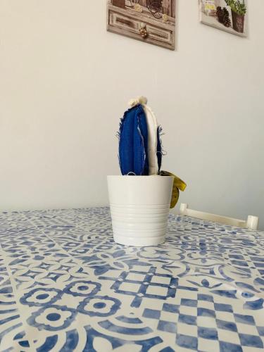 a plant in a white pot sitting on a tile floor at A 100 m dalla spiaggia in Torre Mozza