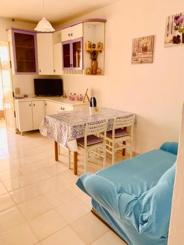 a kitchen with a table and a couch in a room at A 100 m dalla spiaggia in Torre Mozza