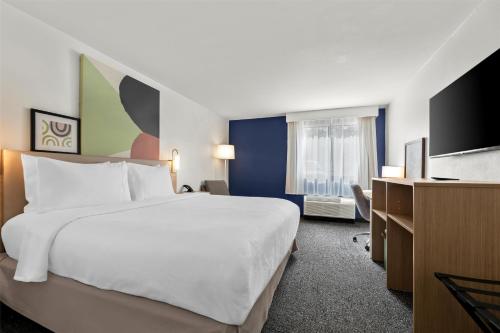 a hotel room with a bed and a flat screen tv at Spark By Hilton Biloxi Ocean Springs in Biloxi