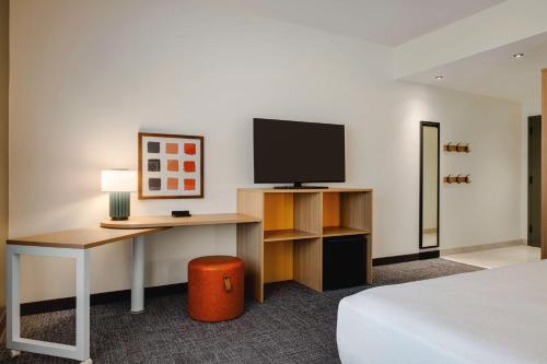 a hotel room with a desk and a television at Spark By Hilton Las Vegas Airport in Las Vegas