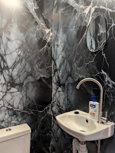 a black marble bathroom with a sink and a mirror at R4 - New Relaxing Double - City & Beach Access, WIFI, Free Parking - Self Catering in Swansea