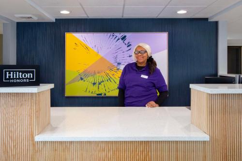 a woman standing behind a counter in a room at Spark By Hilton Rochester University Area in Rochester