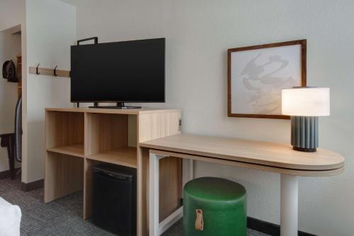 a room with a desk with a television and a lamp at Spark By Hilton Rochester University Area in Rochester