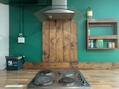 a stove top in a kitchen with a green wall at R4 - New Relaxing Double - City & Beach Access, WIFI, Free Parking - Self Catering in Swansea