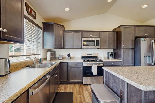 a kitchen with stainless steel appliances and wooden cabinets at Bridger View Retreat in Belgrade