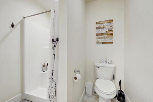 a white bathroom with a toilet and a shower at Bridger View Retreat in Belgrade