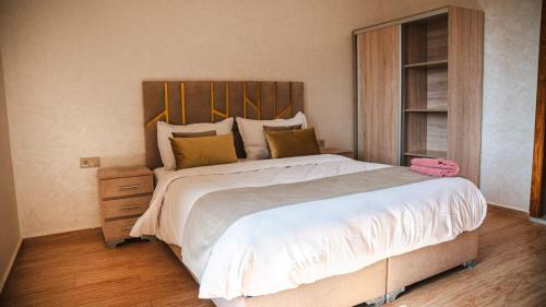 a bedroom with a large bed with a wooden headboard at villa Folki in Oulad Zbir