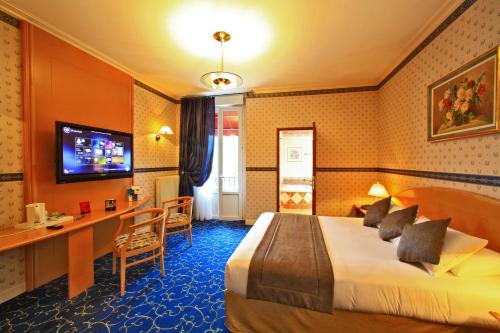 a hotel room with a bed and a desk at Best Western Beauséjour in Lourdes