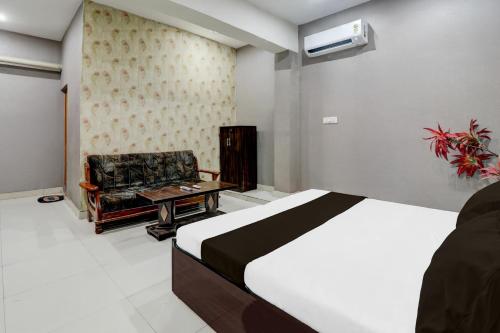 a hotel room with a bed and a chair at HOTEL O YASH RAJ PALACE in Rāe Bareli
