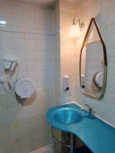 a bathroom with a blue sink and a mirror at Hotel Asturias in Viña del Mar