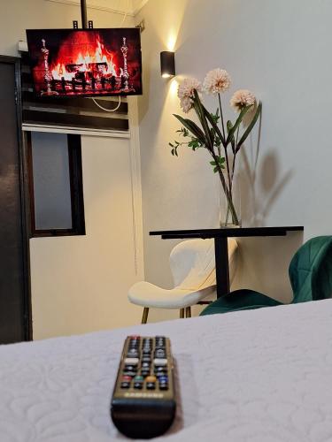 a remote control sitting on a table in front of a television at Hotel Asturias in Viña del Mar