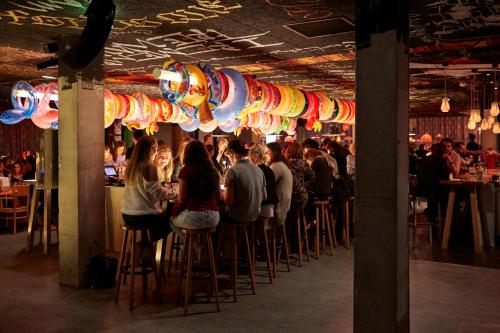 a crowd of people sitting at a bar in a restaurant at Mama Shelter Bordeaux Centre in Bordeaux