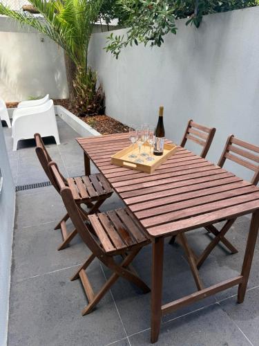 a wooden table with two chairs and a bottle of wine at Vera Cruz Guesthouse in Angra do Heroísmo