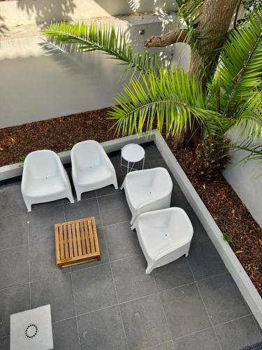 a group of white chairs and tables on a patio at Vera Cruz Guesthouse in Angra do Heroísmo