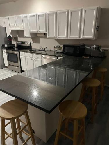 SouthburyにあるPrivate Apt In Southfordsouthburyのキッチン(黒いカウンタートップ、バースツール2つ付)