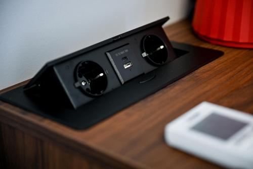 a black speaker sitting on a wooden table at Luxury rooms Iva in Zadar