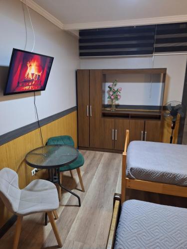 a room with a bed and a table and a tv at Hotel Asturias in Viña del Mar