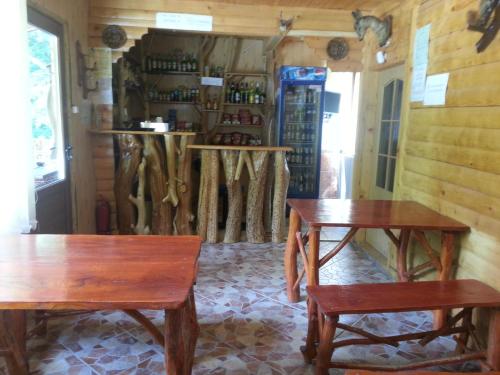 zwei Holztische und Bänke in einem Zimmer in der Unterkunft Pastravaria Romani in Horezu