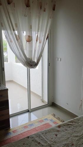 a bedroom with a bed and a large window at Marina Golf Appartement HS in Asilah