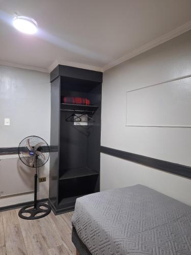 a bedroom with a bed and a fan in a room at Hotel Asturias in Viña del Mar