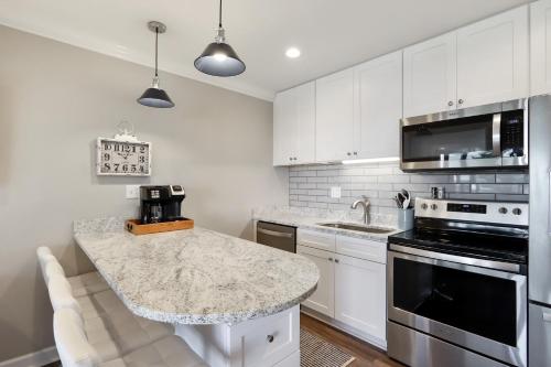 a kitchen with white cabinets and a granite counter top at Unspoiled Beachfront Villa Sunrises from Balcony in Hilton Head Island