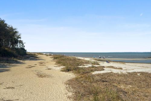 a sandy beach with people in the water at Unspoiled Beachfront Villa Sunrises from Balcony in Hilton Head Island